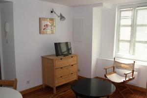 a room with a table and a tv on a dresser at Studio Les Cordeliers centre ville pres du marche in La Rochelle