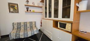 a living room with a microwave and a chair at Ettorina in Cogoleto