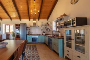 a kitchen with blue cabinets and a wooden ceiling at Casa de Campo La Estancia in Tarifa