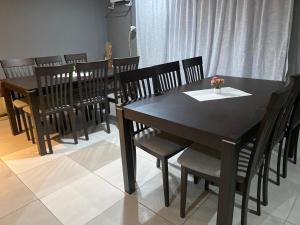 a dining room with a black table and chairs at Galaxy Bed and Breakfast in Butha-Buthe