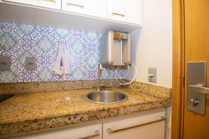 a kitchen counter with a sink and a wall at Ozped Private Flats Saint Moritz in Brasília +277 photos