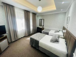 a hotel room with two beds and a television at Hotel Casagrande in Arequipa