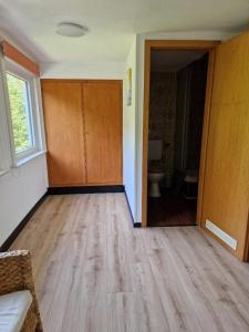 an empty room with a door and a toilet at Pension Haus Sonneck in Wildemann