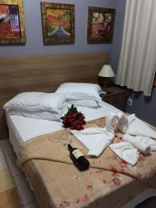 a bedroom with a bed with a bottle of wine at Residencial Quatro Estações in Canela