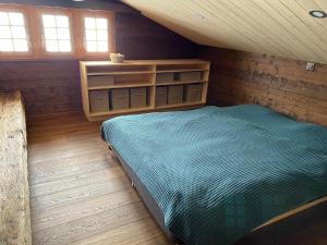 a bedroom with a bed in a wooden cabin at Heimelige Wohnung in einem Walliser Haus in Staldenried