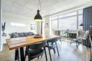 ein Esszimmer und ein Wohnzimmer mit einem Holztisch und Stühlen in der Unterkunft 824 Hvide Sande - Mamrelund 6 2. A in Hvide Sande