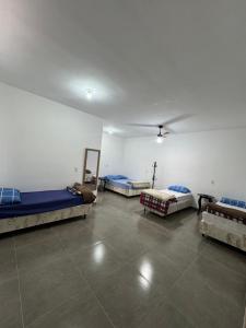 a room with four beds and a ceiling at Hotel Pousa Vale Imperial in Aparecida