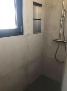 a bathroom with a shower with a mirror and a window at La Casa Fabrielo in Graveson +18 photos