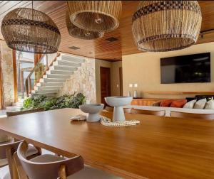 a dining room with a table and two chandeliers at Malhada Jeri in Jericoacoara