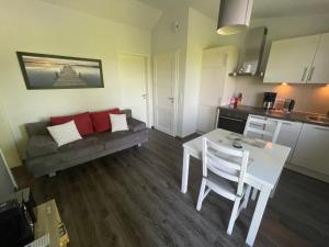 a kitchen and a living room with a table and a couch at Wilsterberg FeWo "Kombi" in Ascheffel