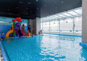 a large swimming pool with a water slide in a building at Căn Hộ "2" OaSky View biển 3 Phòng 5 Giường- Oasky Sea View Apartment in Vung Tau