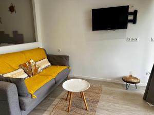 a living room with a couch and a tv on a wall at happy place at anse marcel, private beach in Anse Marcel 
