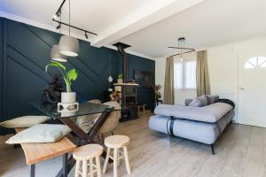 a living room with a couch and a table at Maison du Bonheur avec Rivière & Spa, 4 chambres & 2 SDB in Tourville-en-Auge