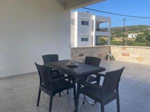 a black table and chairs on a patio at SeaSummerSand Apartment in Chios