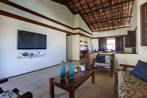 a living room with a couch and a tv at Linda no BEACH PARK-16 pessoas - HOUSINGCEARÁ in Berra Bode