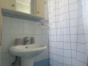 a white bathroom with a sink and a mirror at SeaSummerSand Apartment in Chios