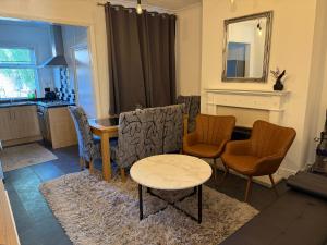 a living room with chairs and a table and a mirror at 3 Bedroom House - Doncaster Serviced Accommodation - House-Close To Centre -A1 & M18 - Contractors - Business Travellers - Families in Doncaster