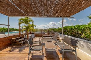 a deck with chairs and a view of the ocean at Papaya Plus in Playa del Carmen
