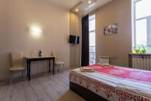 a bedroom with a bed and a table and a window at Sumska 45 in Kharkiv