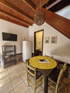 een eetkamer met een tafel en een koelkast bij Pousada das Palmeiras in Garopaba +85 foto's