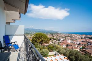 a balcony with chairs and a view of a city at Hotel Indaco in Marina di Casalvelino