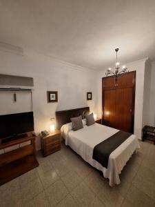 a bedroom with a bed and a flat screen tv at Hotel Portugal in Lepe +50 photos
