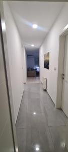 a white hallway with a couch in a room at A-Home apartman in Ši Selo +1 photo