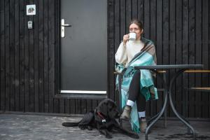 a woman sitting in a chair drinking a cup of coffee with a dog at Castor in Abergele +12 photos