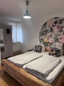 a large bed in a room with a floral headboard at Ländliche Fewo Rose, 4km zum Stausee in Happurg