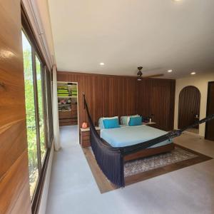 Cama en habitación con hamaca en Spacious and luxurious villa with 4 bedrooms, swimming pool, tennis court, and beach within walking distance, en Playa del Carmen