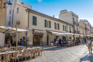 a street with tables and chairs and a group of people at Nautilus Suites & Rooms in Olbia
