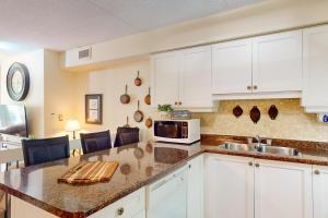 Una cocina con gabinetes blancos y encimera. en Chateau Ridge 109, en Blue Mountains