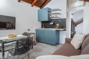 a kitchen with blue cabinets and a table in a room at Nautilus Suites & Rooms in Olbia