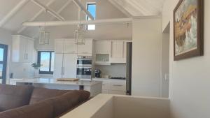 a living room with a couch and a kitchen at Witsand Holiday House in Witsand