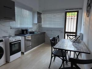 a kitchen with a table and a table and chairs at Villia home in Vília