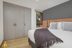 a bedroom with a large white bed and a window at Ankara 302 - Clean Comfy Loft Trendy in Provenza in El Poblado