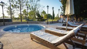 a pool with two loungers and an umbrella at Winds Hill Resort & Spa in Merlo