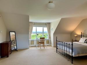 a bedroom with a bed and a desk and a window at Grianán in Ballyconneely