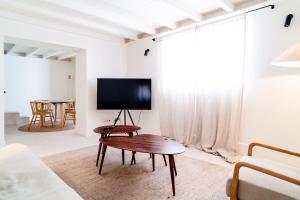 a living room with a table and a flat screen tv at Castelo House in Castelo de Vide