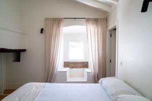 a bedroom with a bed in front of a window at Castelo House in Castelo de Vide