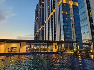 a large building with a pool in front of it at Pollux Habibie Batam Polux in Batam Center
