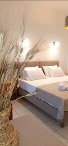 Un dormitorio con dos camas y un jarrón con flores. en ZOGRAFOS SPIROS Rooms, en Perdika