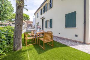 a patio with a table and chairs and a tree at Casa Orizzonte - Appartamento con vista in Gabicce Mare
