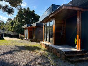 a small house with glass doors on the side of it at Hospedaria Cambará in Cambará