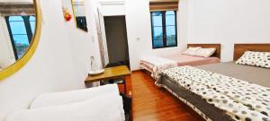 a room with two beds and a mirror at Rose Homestay Cầu Ngói in Thôn Trường Giang