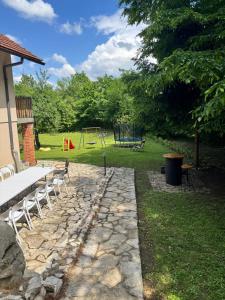 Un camino de piedra con una mesa de picnic y un parque infantil. en Rancbl, en Banja Luka