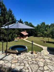un patio con sombrilla y piscina en Rancbl, en Banja Luka