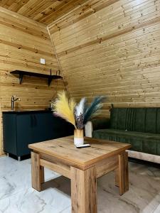 Una mesa de madera con un jarrón de plumas encima. en Panorama cottage Martvili, en Martvili