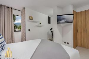a bedroom with a bed and a tv on the wall at Aria Living 300 - Style and Urban Comfort in Guayaquil