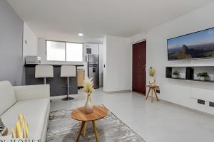 a white living room with a white couch and a table at Aria Living 300 - Style and Urban Comfort in Guayaquil +12 photos